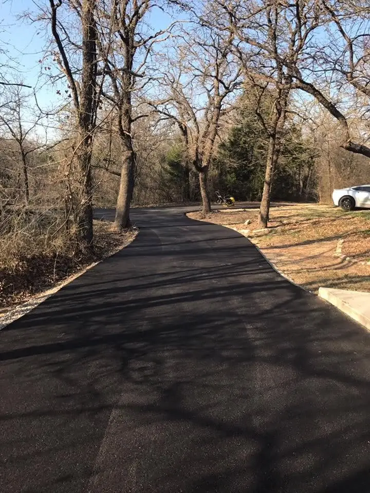Fresh blacktop driveway winding through an oak woodland