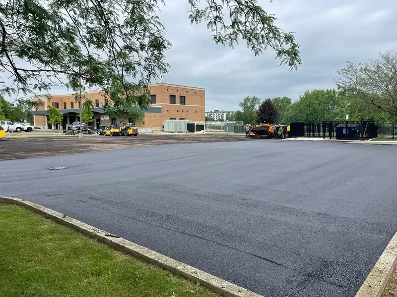 Freshly paved lot beside a brick office building
