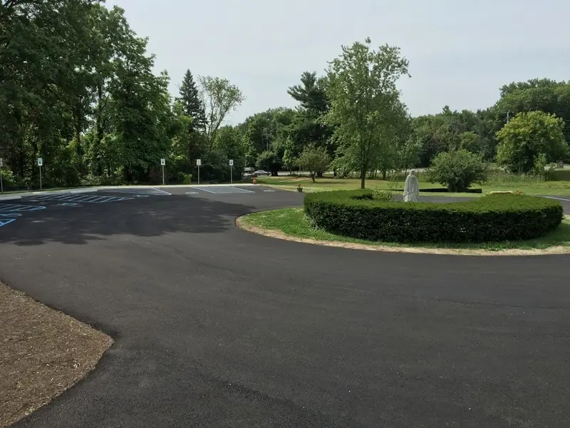 Commercial parking lot with a fresh, even black sealcoat around a landscaped island